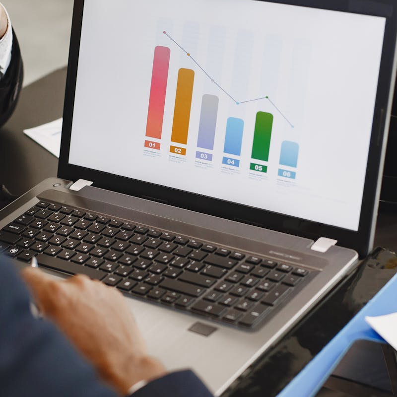 Two professionals analyzing a business graph on a laptop during a meeting.